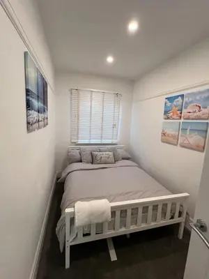 a bedroom with a bed in a white room at Salvation View 2 Bed Apartment in Hadleigh