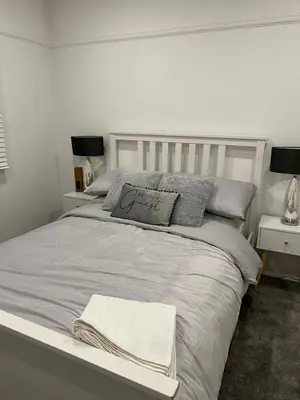 a white bedroom with a bed and two night stands at Salvation View 2 Bed Apartment in Hadleigh