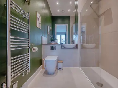 a bathroom with a toilet and a glass shower at Cambridge - hot tub, sauna, parking, pool table in Trumpington
