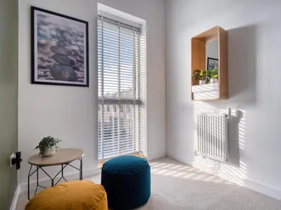 a room with a window with a table and a stool at Cambridge - hot tub, sauna, parking, pool table in Trumpington