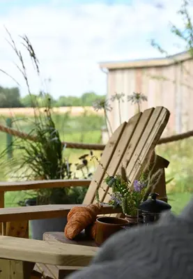 a wooden chair with a table with a loaf of bread at The Farmstead in Euston