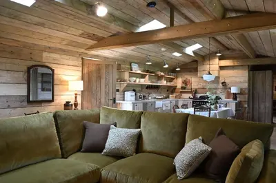 a living room with a couch and a kitchen at The Farmstead in Euston
