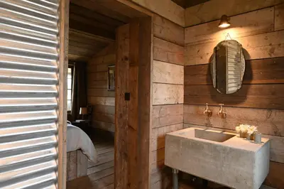 a bathroom with a sink in a wooden wall at The Farmstead in Euston