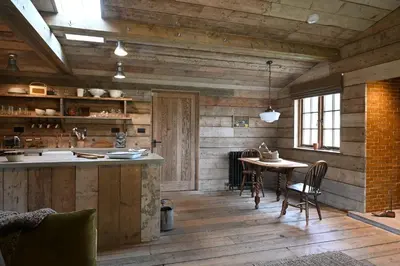 a kitchen with wooden walls and a table with chairs at The Farmstead in Euston