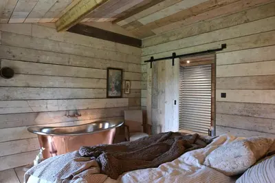 a bedroom with a bed in a room with wooden walls at The Farmstead in Euston