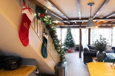 a living room with christmas decorations on the wall at Chinnerys Country Cottage in Cavendish