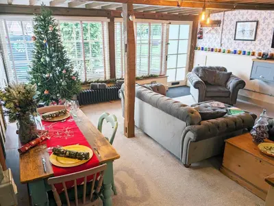 a living room with a christmas tree and a table at Chinnerys Country Cottage in Cavendish