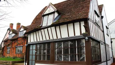 an old house with white and black windows at Chinnerys Country Cottage in Cavendish