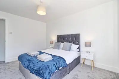 a bedroom with a large bed with a blue blanket at 3 Bed, Sleeps 6, Wifi, Free Parking in Writtle
