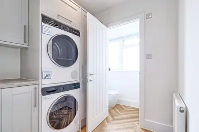 a white laundry room with two washer and dryer at 3 Bed, Sleeps 6, Wifi, Free Parking in Writtle