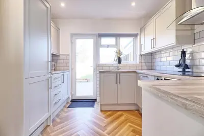 a kitchen with white cabinets and a large window at 3 Bed, Sleeps 6, Wifi, Free Parking in Writtle