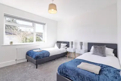 a bedroom with two beds and a window at 3 Bed, Sleeps 6, Wifi, Free Parking in Writtle