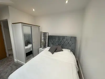 a bedroom with a large white bed with a mirror at Stunning 2-bed house in Great Warley, Brentwood in Great Warley Street