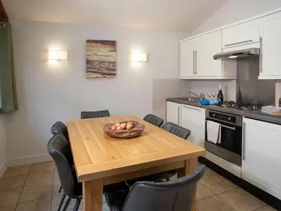 a kitchen with a wooden table with a bowl of fruit on it at Thorpe Forest Cabins - Forest Holidays in Thetford