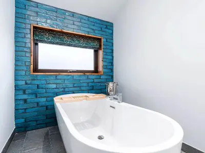 a bathroom with a white tub and a window at Thorpe Forest Cabins - Forest Holidays in Thetford