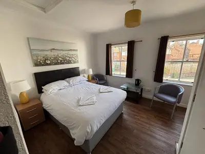 a bedroom with a bed and two windows at Ipswich Inn in Ipswich