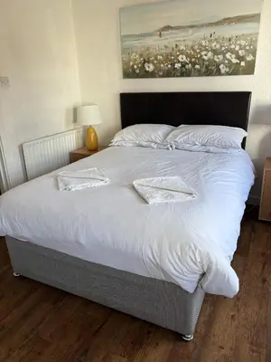 a large bed with white sheets and pillows at Ipswich Inn in Ipswich