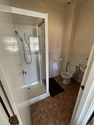 a bathroom with a shower and a toilet at Ipswich Inn in Ipswich
