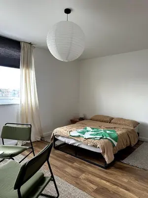 a bedroom with a bed and a chair and a lamp at Flat-on-Sea in Southend-on-Sea