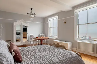 a bedroom with a bed and a table and windows at 4 Bed in Aldeburgh oc-e28371 in Aldeburgh