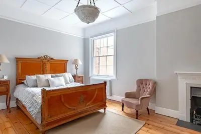 a bedroom with a bed and a chair and a fireplace at 4 Bed in Aldeburgh oc-e28371 in Aldeburgh