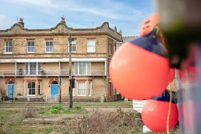 an old brick building with orange balls in front of it at 4 Bed in Aldeburgh oc-e28371 in Aldeburgh