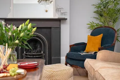 a living room with a blue chair and a fireplace at 4 Bed in Aldeburgh oc-e28371 in Aldeburgh