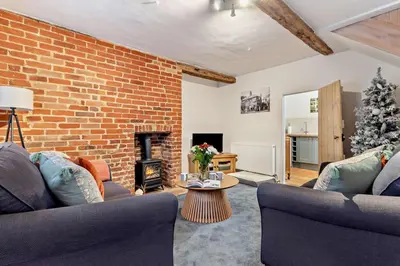 a living room with two couches and a brick wall at 2 Bed in Lavenham oc-t30056 in Lavenham