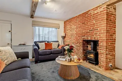 a living room with a couch and a brick fireplace at 2 Bed in Lavenham oc-t30056 in Lavenham