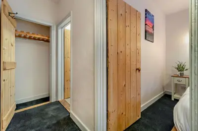 a bedroom with wooden doors and a closet at 2 Bed in Lavenham oc-t30056 in Lavenham