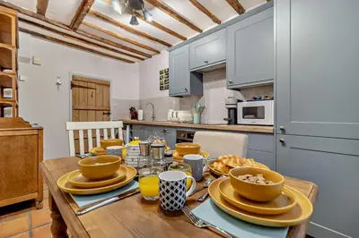 a kitchen with a wooden table with dishes on it at 2 Bed in Lavenham oc-t30056 in Lavenham