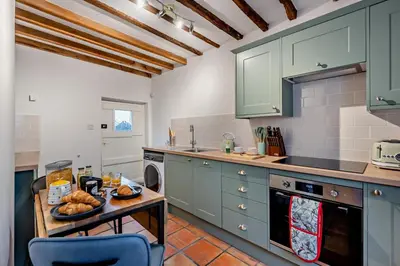 a kitchen with green cabinets and a table with bread on it at 2 Bed in Lavenham oc-f30054 in Lavenham