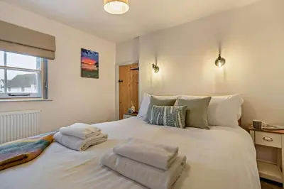 a bedroom with a large white bed with towels on it at 2 Bed in Lavenham oc-s30055 in Lavenham