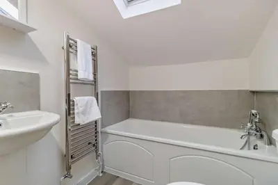 a white bathroom with a tub and a sink at 2 Bed in Lavenham oc-s30055 in Lavenham
