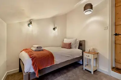 a small bedroom with a bed and a night stand at 2 Bed in Lavenham oc-s30055 in Lavenham