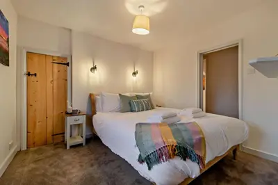 a bedroom with a large white bed with a colorful blanket at 2 Bed in Lavenham oc-s30055 in Lavenham