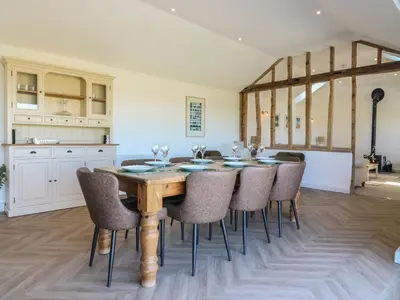 a kitchen and dining room with a wooden table and chairs at The Hide in Colchester