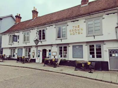 a white building with benches in front of it at The Crown Hotel in Framlingham