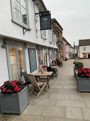 a street with tables and chairs in front of a building at The Crown Hotel in Framlingham