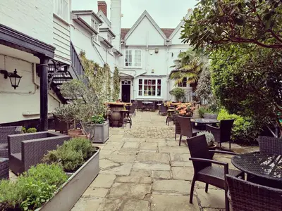 an outdoor patio with tables and chairs and a table at The Crown Hotel in Framlingham