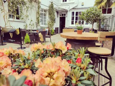 a patio with flowers and a table and chairs at The Crown Hotel in Framlingham