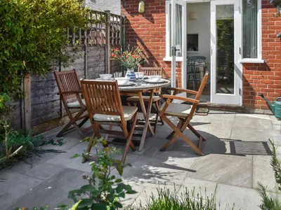 a wooden table and chairs on a patio at Eva's Cottage in Wenhaston