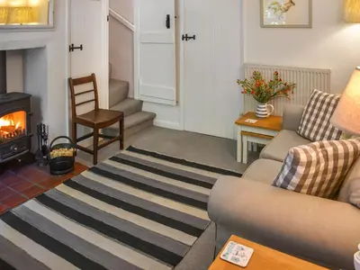 a living room with a couch and a fireplace at Eva's Cottage in Wenhaston