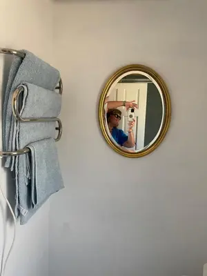 a mirror on a wall with a man taking a picture at Barn conversion Corner Annexe in Earls Colne