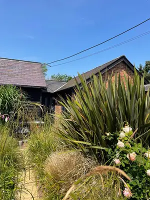 a house with a large plant in front of it at Barn conversion Corner Annexe in Earls Colne