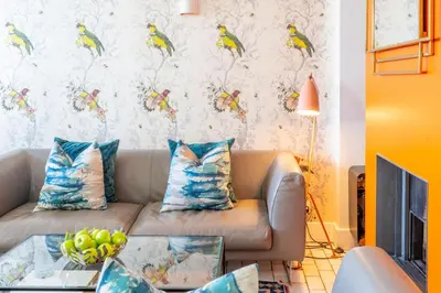 a living room with a couch with a bird wallpaper at Edinburgh House in Aldeburgh