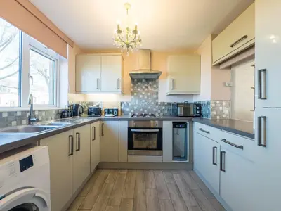 a kitchen with white cabinets and a dishwasher at Basildon Retreat Cozy 3-Bedroom Home in Basildon
