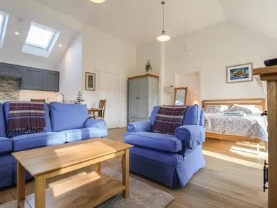 a living room with blue couches and a bed at West End in Woodbridge