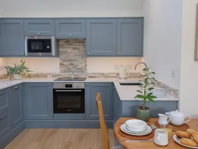 a kitchen with blue cabinets and a wooden table at West End in Woodbridge