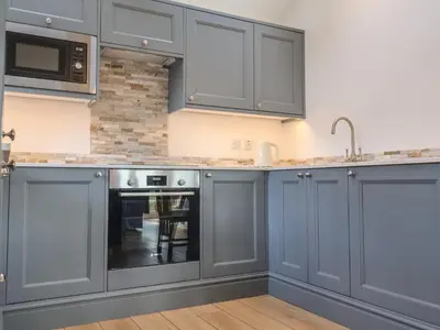 a kitchen with gray cabinets and a sink at West End in Woodbridge